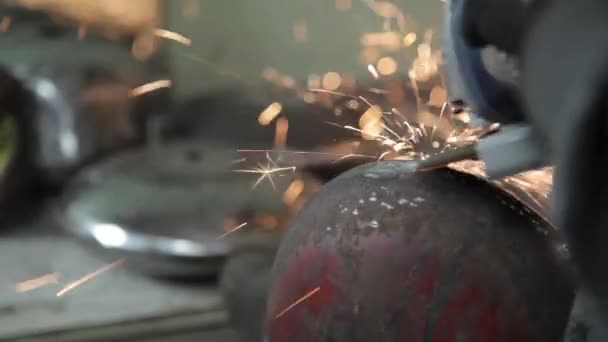 Angle Grinder grève étincelles dans un garage sombre exécutant l'assistant pour la production d'un tambour en métal étincelles magiques polissage de la surface d'un vieux sac à gaz résultats nettoie la surface métallique du sac à gaz — Video