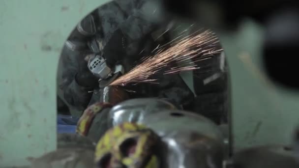 Angle Grinder grève étincelles dans un garage sombre exécutant l'assistant pour la production d'un tambour en métal étincelles magiques polissage de la surface d'un vieux sac à gaz résultats nettoie la surface métallique du sac à gaz — Video