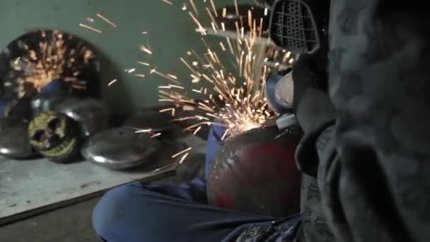 Angle Grinder grève étincelles dans un garage sombre exécutant l'assistant pour la production d'un tambour en métal étincelles magiques polissage de la surface d'un vieux sac à gaz résultats nettoie la surface métallique du sac à gaz — Video