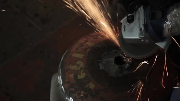 Angle Grinder strike sparks in a dark garage running the wizard for the production of a metal drum magic sparks polishing the surface of an old gas bag results cleans the metal surface of the gas bag — Stock Video