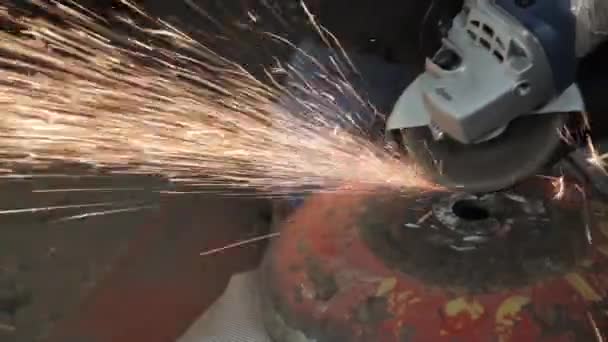 Angle Grinder grève étincelles dans un garage sombre exécutant l'assistant pour la production d'un tambour en métal étincelles magiques polissage de la surface d'un vieux sac à gaz résultats nettoie la surface métallique du sac à gaz — Video