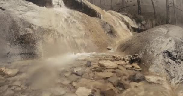 Pequenas cachoeiras fluxo de água sobre as rochas no nevoeiro em uma floresta de montanha — Vídeo de Stock