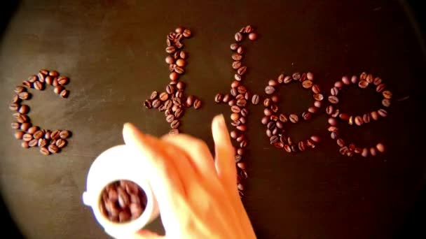 The inscription COFFEE made by women on the table from coffee beans Robusta and cups, — Stock Video