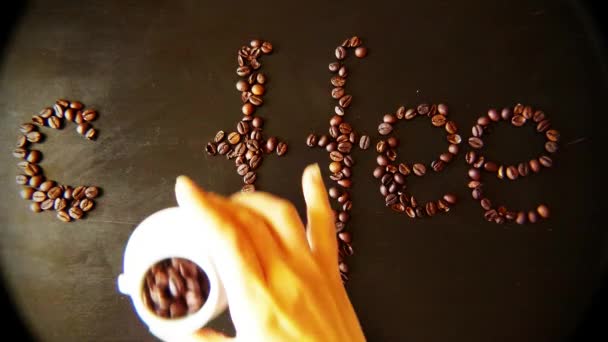 Die Inschrift Kaffee von Frauen auf dem Tisch aus Kaffeebohnen Robusta und Tassen, — Stockvideo