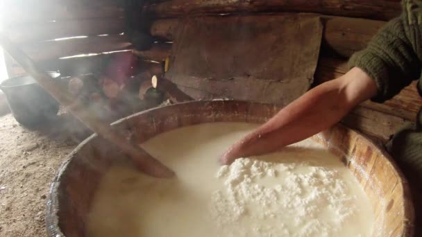 Mano contadino bussa e raccoglie il formaggio preparato da un barile di legno primo piano — Video Stock