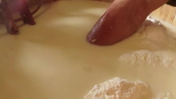 Mano selecciona queso caliente de una olla grande en las viejas tradiciones de las montañas — Vídeos de Stock