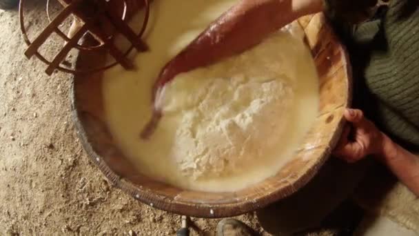 Barril de madera con queso caliente, manos de granjero en la leche, vista superior — Vídeo de stock