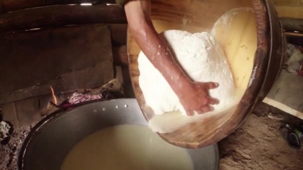 Large piece of feta cheese in a wooden tub decanted from residual liquid on the background of the barracks of the Shepherds — Stock Video