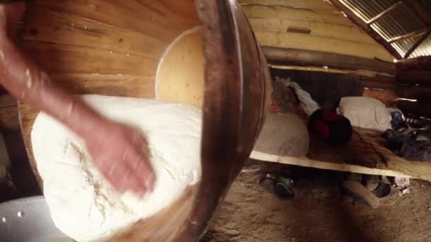 Gran pedazo de queso feta en una tina de madera decantado de líquido residual en el fondo de los cuarteles de los pastores — Vídeos de Stock