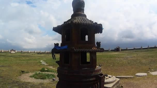 Colombes marchent près du mur en bois d'un bâtiment bouddhiste et de l'ancien monastère au loin Erdene Zuu monastère bouddhiste l'un des plus anciens monuments de Mongolie — Video