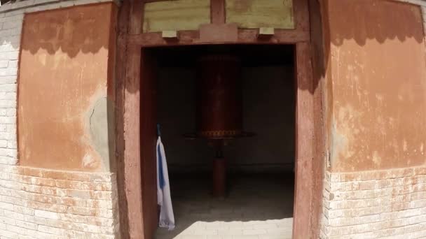 Antigua bobina de rueda de oración budista gira lentamente en una puerta de un antiguo templo Erdene Zuu monasterio budista uno de los monumentos más antiguos de Mongolia — Vídeo de stock