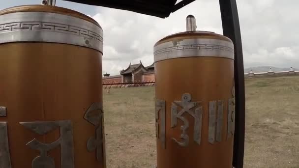 Mujer gira tambores de oración budistas en los que se escriben el mantra Erdene Zuu monasterio budista uno de los monumentos más antiguos de Mongolia — Vídeos de Stock