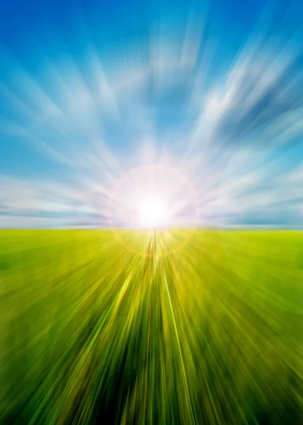 Abstrakte Bewegung verschwimmt Wiese und Himmel mit Sonne — Stockfoto