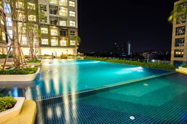 kat mülkiyeti ve Yüzme Havuzu gece zaman 