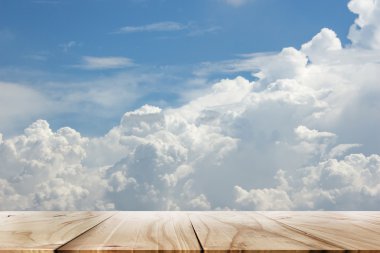 Beyaz bulutlu ahşap masa ve mavi gökyüzü.
