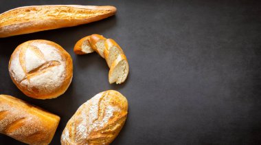 Çeşitli somunlar, baget ekmeği ve ev yapımı zanaatkar ekmeği dilimleri. Metin ve afiş için boşluk ve kopyalama alanı ile
