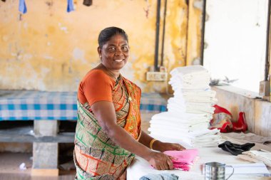 Geleneksel kıyafet katlayan kadın, Dhobi Ghat, Kochi, Hindistan 'da hava çamaşırları, 20 Mart 2025
