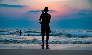 Güney Hindistan 'daki Colva Goa sahilinde gün batımı, insan silueti, tropikal batı kıyısı, Asya' daki Arap Denizi, tatil yeri, 8 Mart 2025
