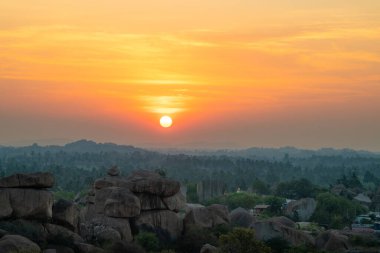 Hemakuta Hill 'den Hampi, gün batımı manzaralı, palmiye ağaçlı kaya manzaralı, Hindistan' da Karnataka, seyahat yeri.