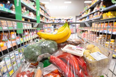 Taze sebzeler, meyveler ve çikolata, yiyecekli alışveriş arabası, market alışverişi, süpermarket, Trier, Almanya, 30 Ocak 2026