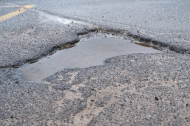 Asfalt yoldaki çukur, su birikintisi, yağmur üstüne su çukuru, Almanya 'daki caddenin durumu, hasarlı otoyol, tehlikeli yüzey