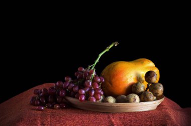 Siyah arkaplanı olan üzüm ve diğer meyveler.