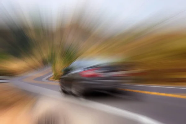 Car on asphalt road in countryside racing through with motion background.
