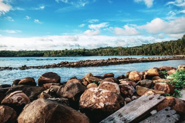 Gökyüzü renklerle dolu kumsaldaki taş.