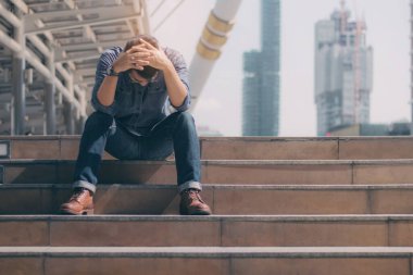 Şehirde gergin bir genç adam oturuyor..