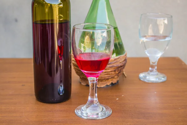 Copa de vino tinto y conjunto de botellas —  Fotos de Stock