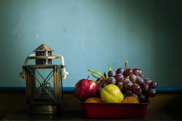 Fruit in dienbladen en lampen op tafel — Stockfoto