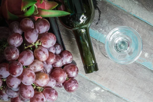 Druiven en wijn flessen liggen — Stockfoto