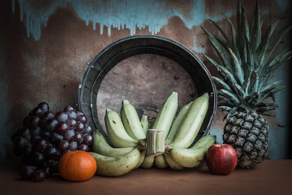 Бананы и фрукты на деревянном столе . — стоковое фото