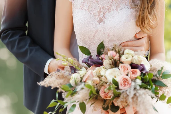 Brudgummen omfamnar försiktigt bruden bakom — Stockfoto