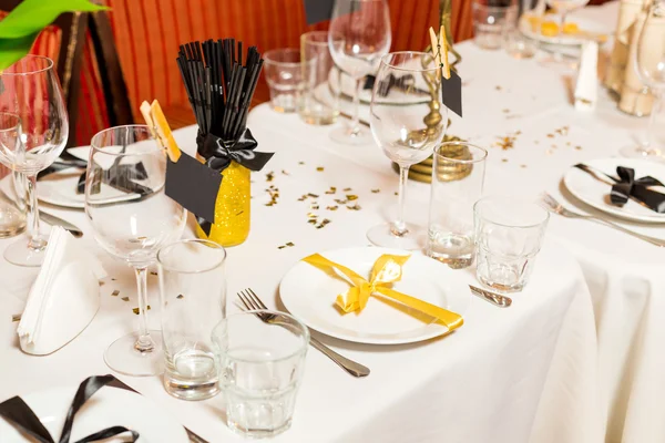 Birthday guests table setting with fresh flowers in black and gold style, indoor — Stock Photo, Image
