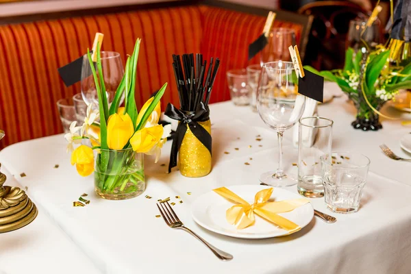 Ajuste de mesa para invitados de cumpleaños con flores frescas en estilo negro y dorado, interior — Foto de Stock