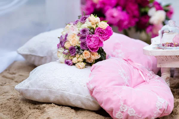 Mooie, gevoelige bruids boeket onder decoraties met kussen — Stockfoto