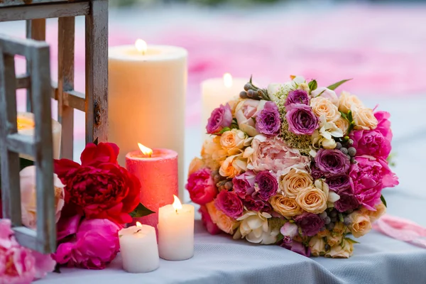 Mooie, gevoelige bruids boeket onder decoratie met kaarsen en verse bloemen — Stockfoto