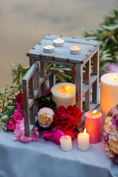 Vakre, delikate brudebukett blant dekorasjoner med lys og friske blomster – stockfoto