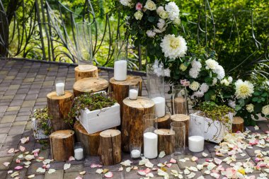 Yeni evliler kırsal tarzda dekore edilmiş. Çiçekli, mumlu, sulu, yeşillikli ve ahşap elementli düğün dekoru. Evlilik töreni dekorasyonunda doğa teması