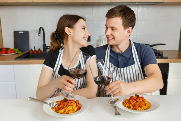 Happy Couple Aprons Eating Bolognese Pasta Wine Modern Kitchen Romantic — Stock Photo, Image