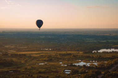 Mavi günbatımı gökyüzü, bulutlar, tarlaların üzerinde uçan yalnız bir balon, Rusya 'nın kırsal kesimlerinde günbatımında orman ve yangınlar