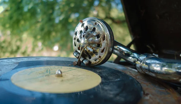 Vintage record player with a vinyl record on a background of trees