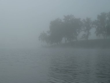 Göl kenarında sisli bir sabah.