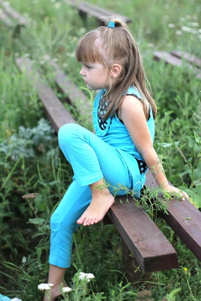 Kleines Mädchen mit langen Haaren spielt im Sommer auf Gras — Stockfoto