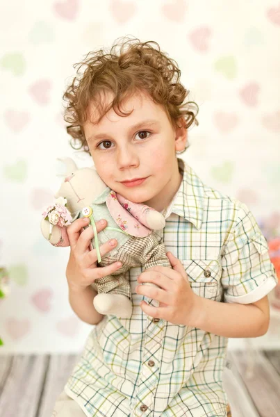 Porträtt av lockigt brown-eyed boy i en ljus beige klänning — Stockfoto