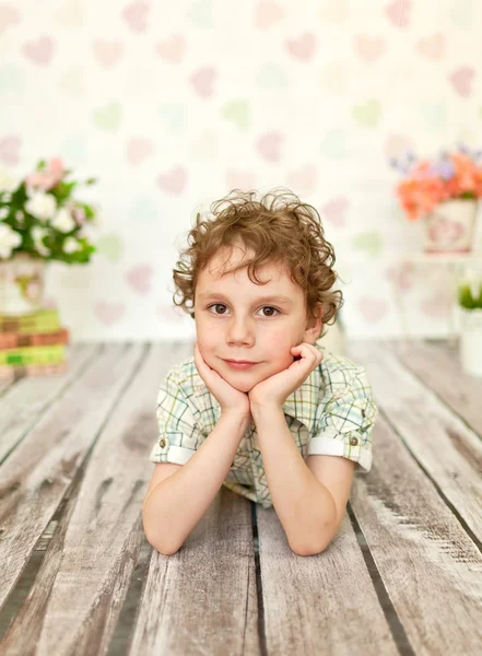 Portret van krullend bruin-eyed jongen in een licht beige jurk — Stockfoto