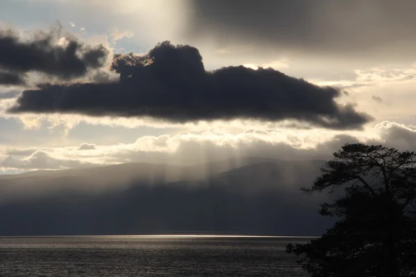 Natur des Baikalsees, Insel Olchon, Russland, graue Wolke über dem See bei Sonnenuntergang, wunderschöne Natur des Baikalsees, wunderschöner Sonnenuntergang mit orange-gelbem Himmel mit Wolken am See, Fluss — Stockfoto