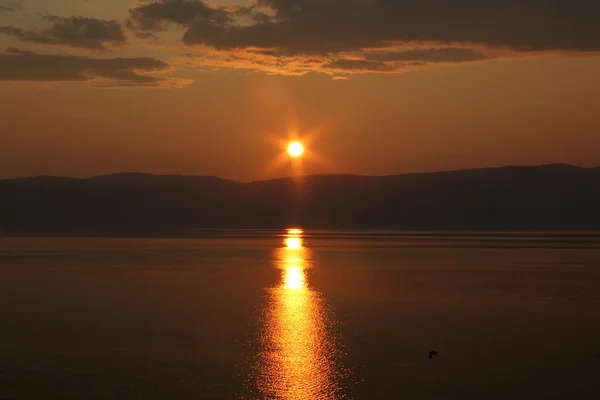 Baykal Gölü'nün güzel doğası, gölde bulutlar ile turuncu-sarı gökyüzü ile güzel gün batımı, nehir, akşam göl, Baykal gölügüzel günbatımı, Olkhon Adası, Rusya, 