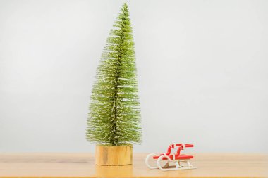 Gri arka planda Noel ağacı ve Noel kızağı